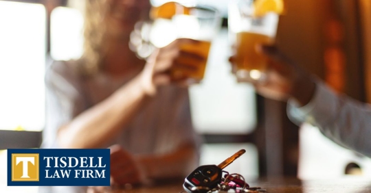 two people drinking with a car keys in front of them