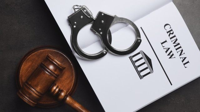 Judge's gavel, handcuffs and Criminal law book on grey background, flat lay