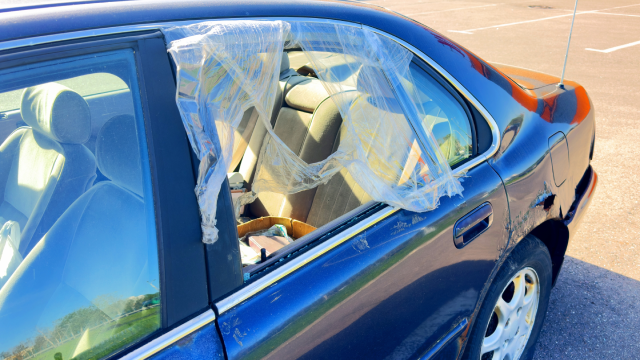 Broken car window. Car robbery. The thief broke the glass in the car window. Vandal broke car window